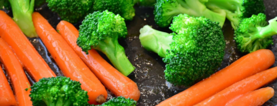FOto af gulerødder og broccoli på en stegepande